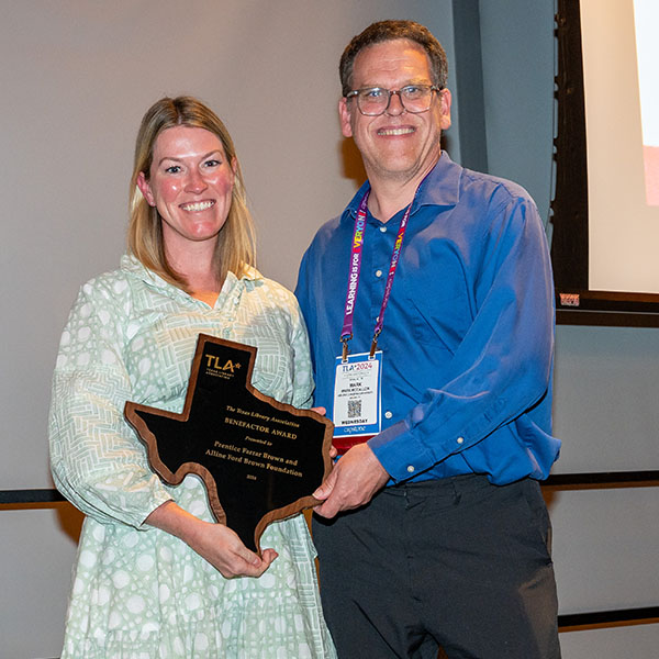 Woman receiving award from man at 2024 TLA Annual Conference Opening Awards and Author Luncheon.