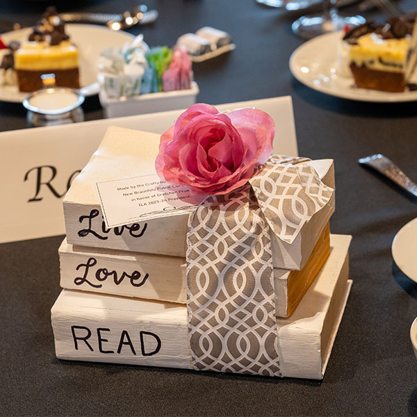 Stack of books on table Speaker at 2024 TLA Annual Conference Opening Awards and Author Luncheon.