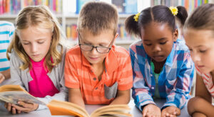 4 children, one boy and three girls reading books
