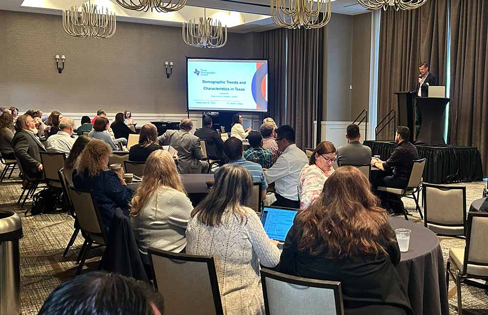 TCAL 2025 Annual Conference group seated at tables listening to a speaker at the podium