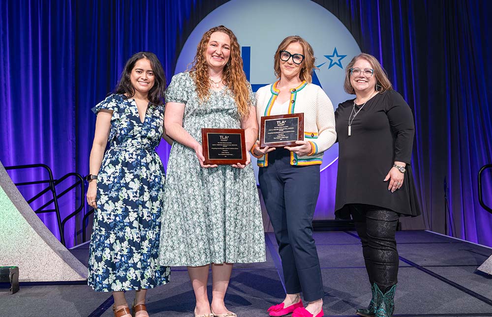 Four women, two with an award onstage at the TLA Annual Conference